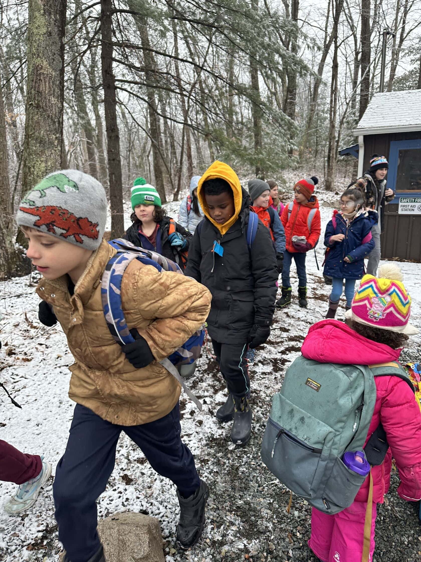 A group of kids hikes during winter.