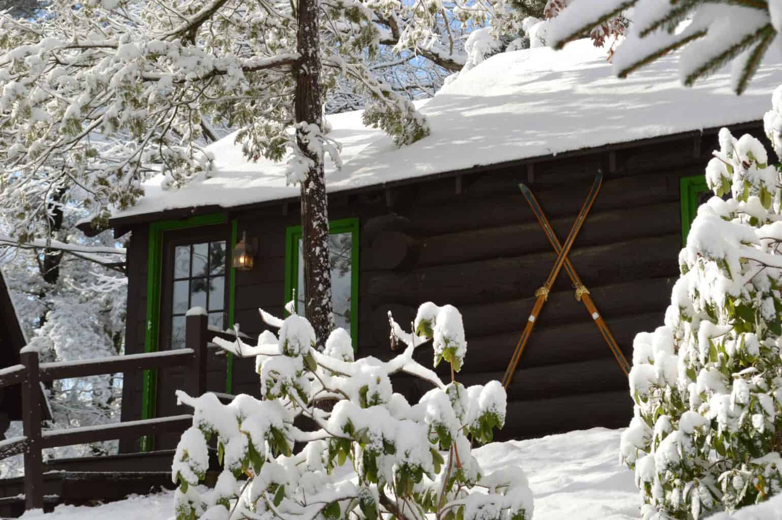 Winter cabin covered in snow.
