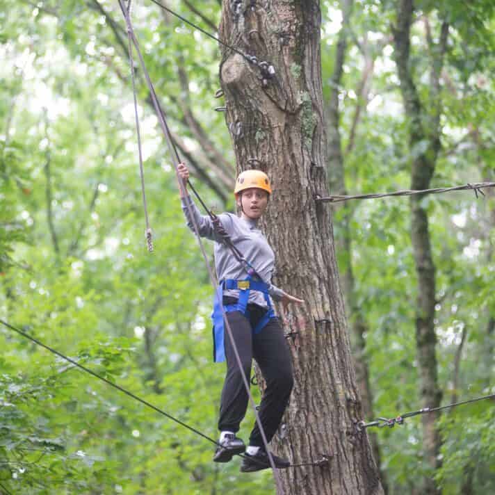 Person inching along high ropes course.