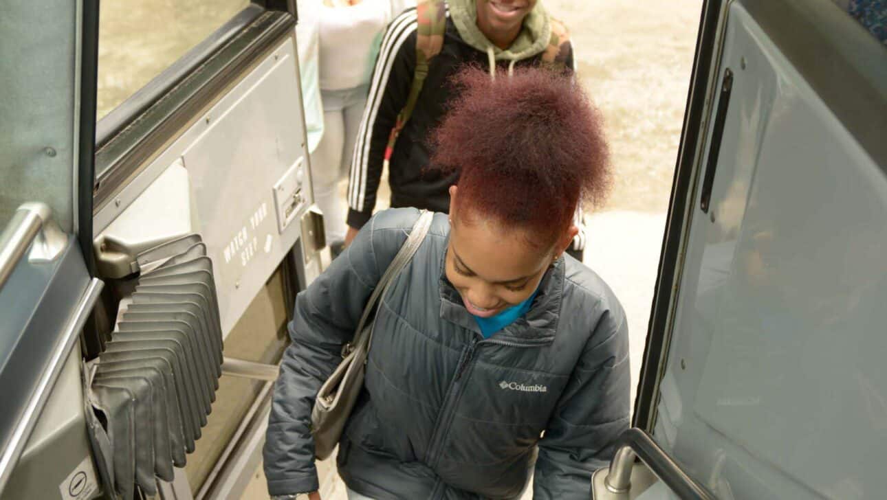 Teens getting on bus.