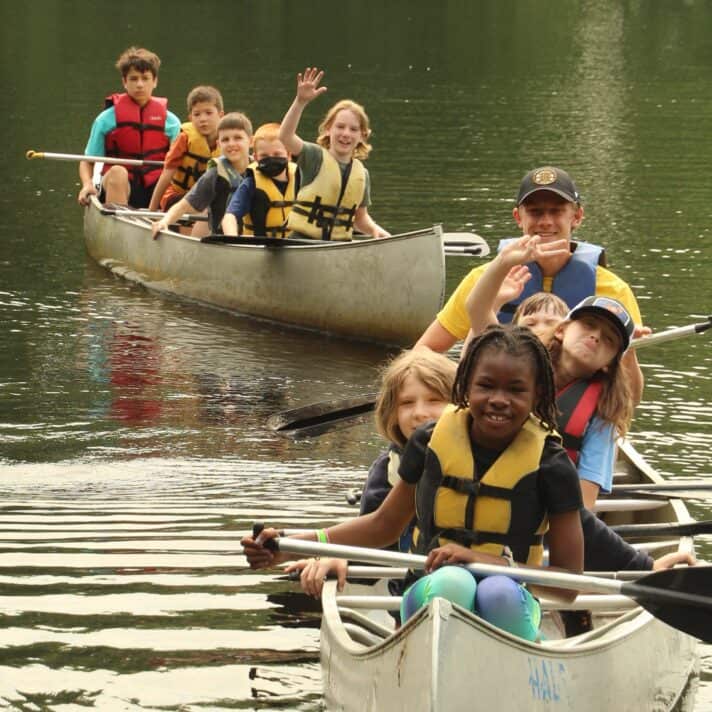 Kids rowing canoes.