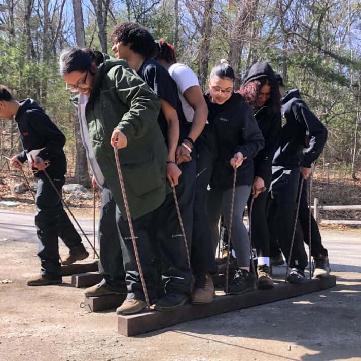 High school students work together on a teambuilding challenge