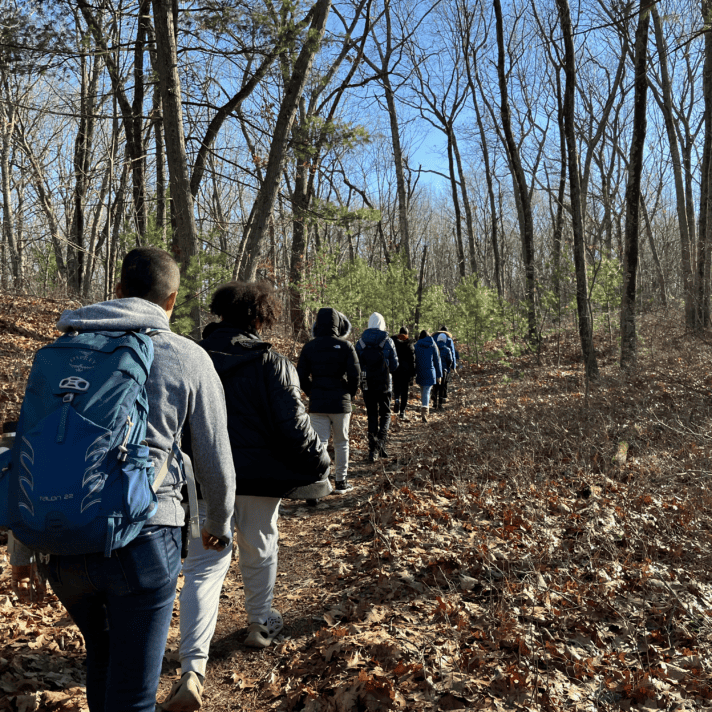 Group of high school students hiking through woods