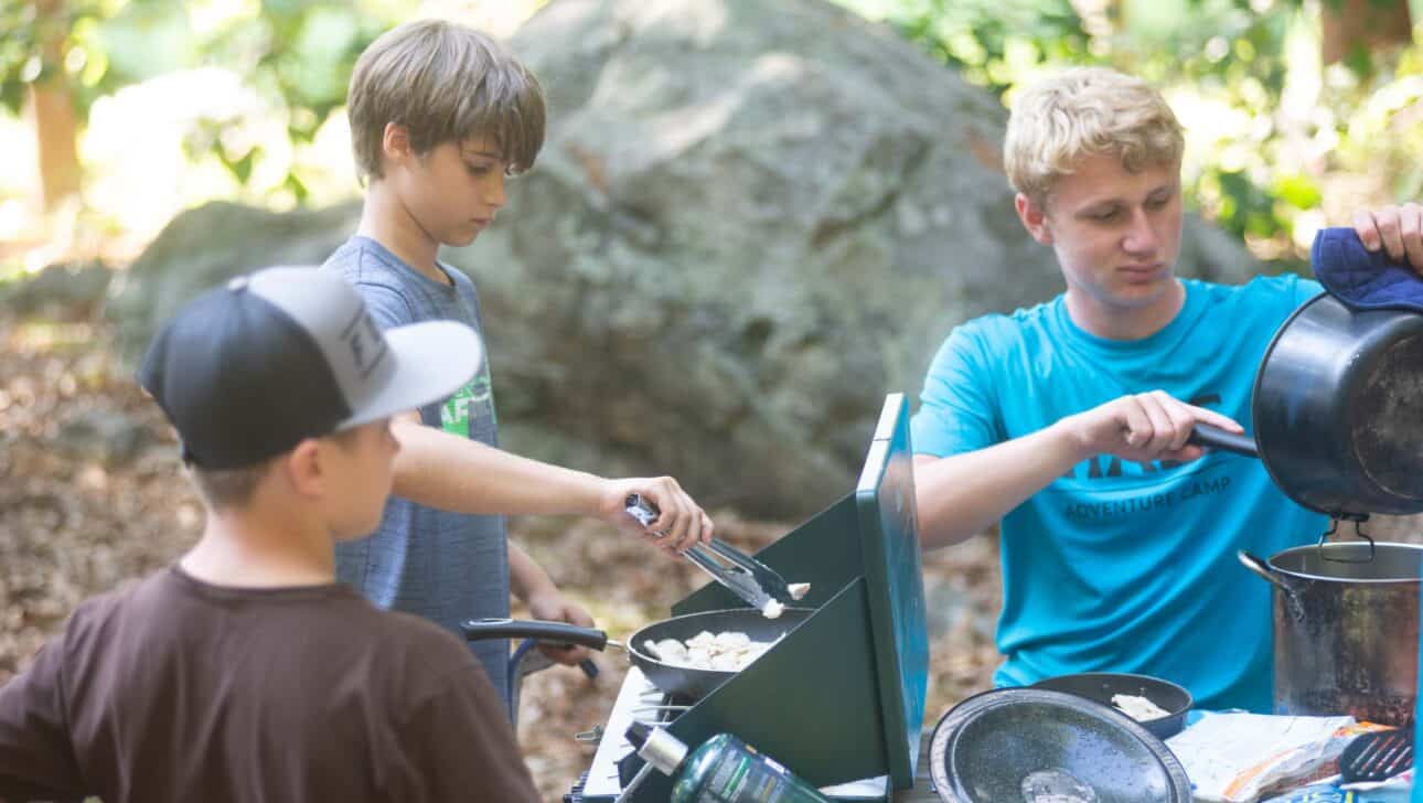 Campers cooking in the woods.