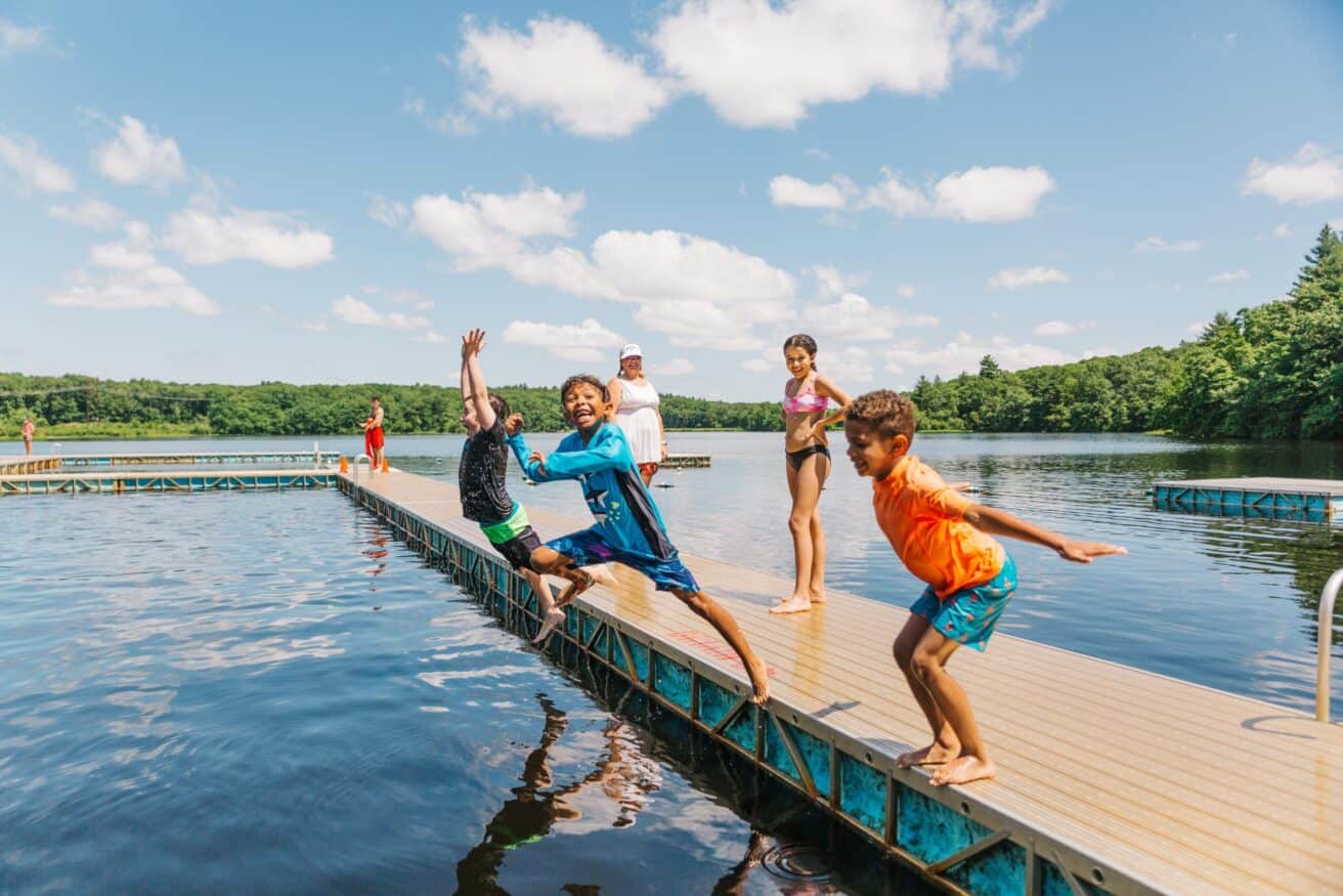Kids jumping off lake dock in the summer.