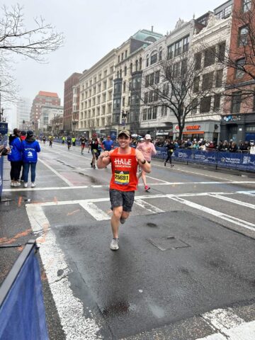 A Boston Marathon runner shows off his Team Hale singlet