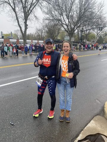 A Boston Marathon runner poses for a photo with a fan