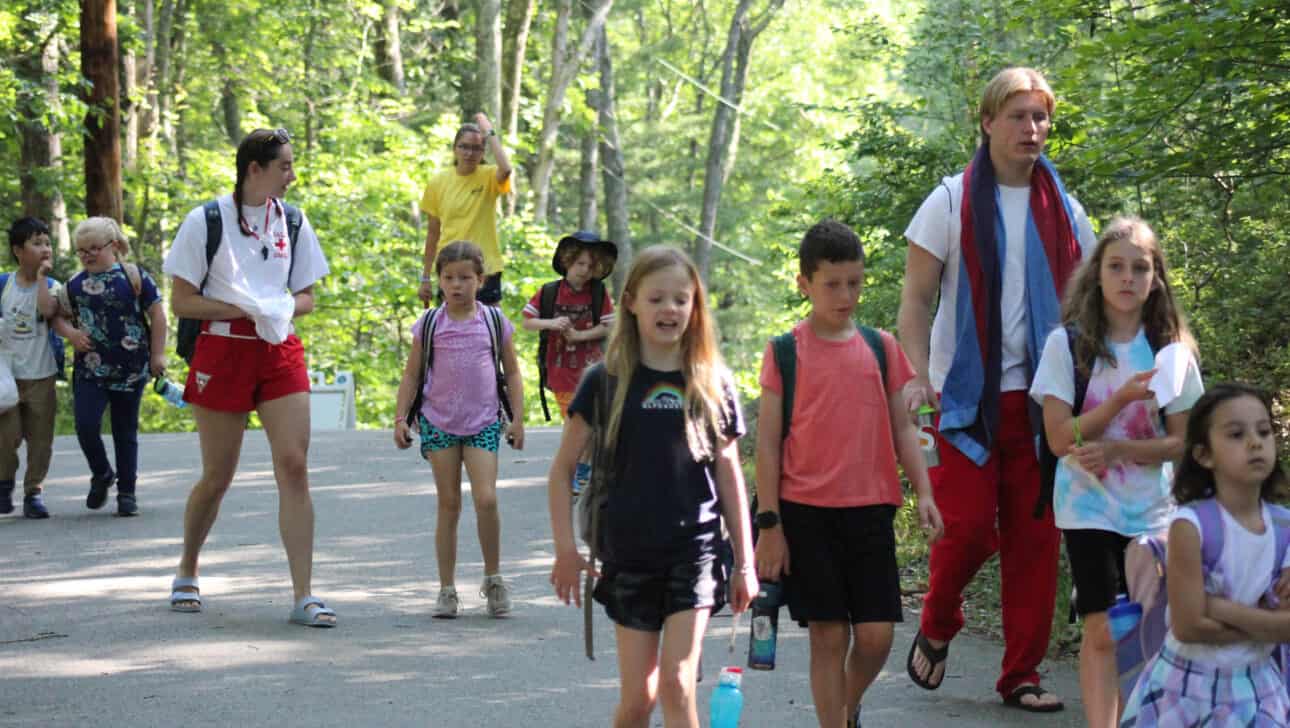 Counselors in Training walking with campers on a path.