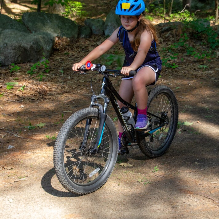A middle school girl on a mountain bike.