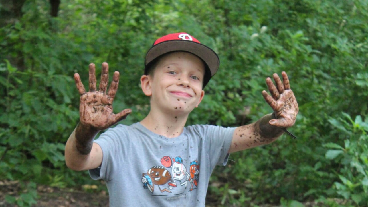 A boy with mud on his hands.