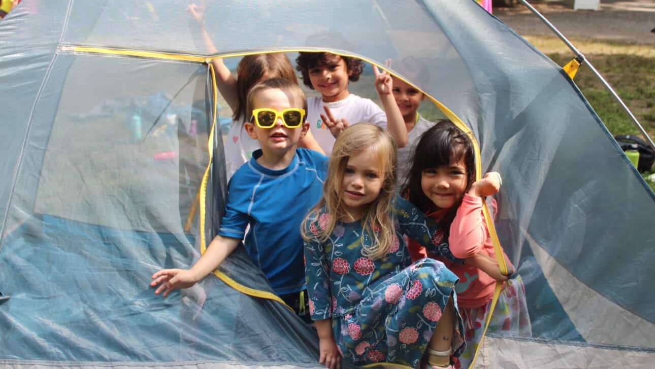 A group of children in a tent with sunglasses.