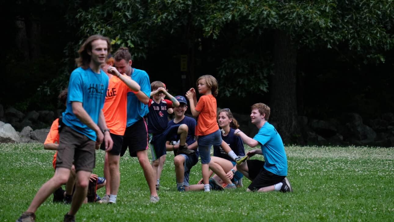 Counselors playing with campers on a field.