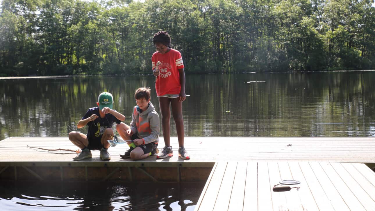 Kids on a dock collecting things for science.