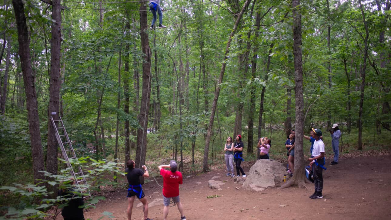 Members from English High complete a team building exercise outside.