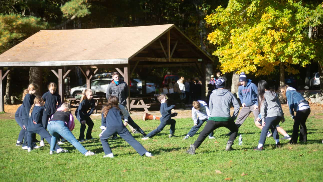 Members from St. John School complete a team building exercise outside.