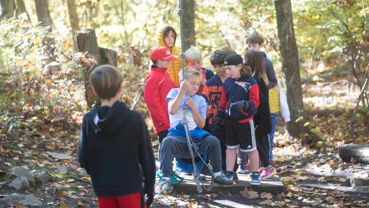 Members from Carroll School complete a team building exercise outside.