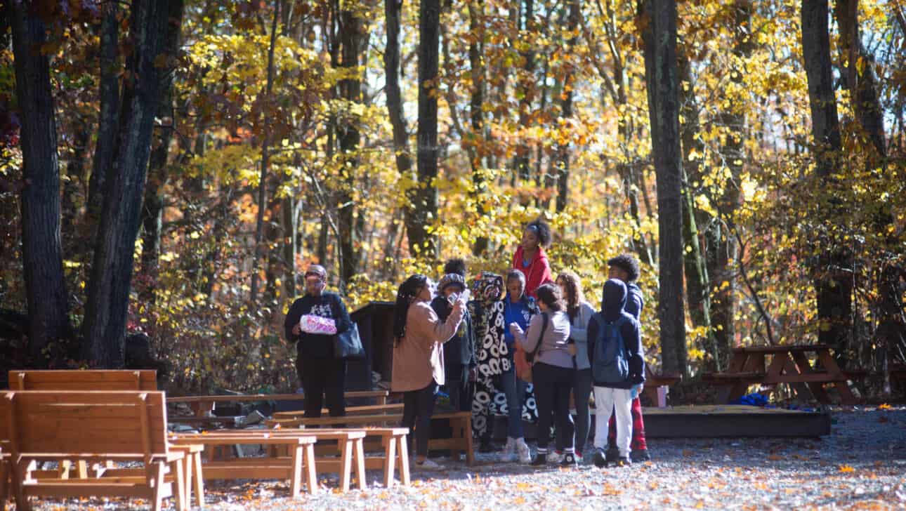 Members from Boston Arts Academy complete a team building exercise outside.