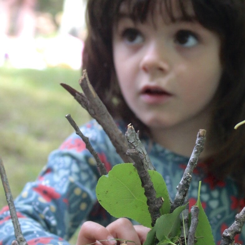 A young child explores nature.