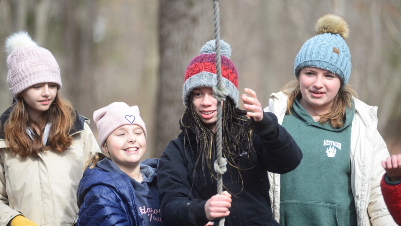A group of kids on a ropes course during school vacation.