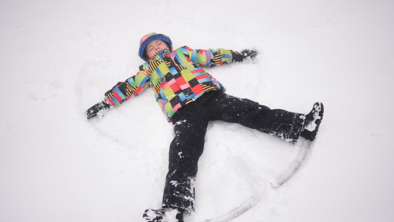 A child makes a snow angel in freshly fallen snow