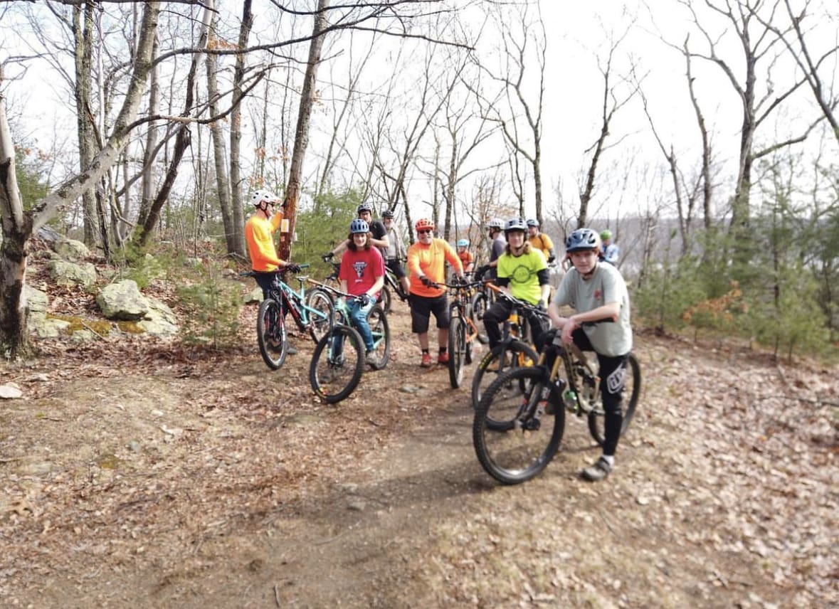 A group of kids goes mountain biking during the winter.