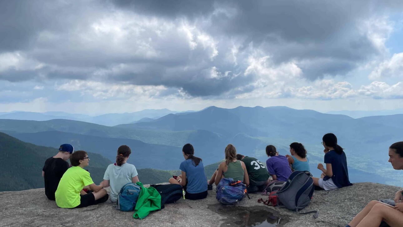 A group of people sitting on top of a mountain.