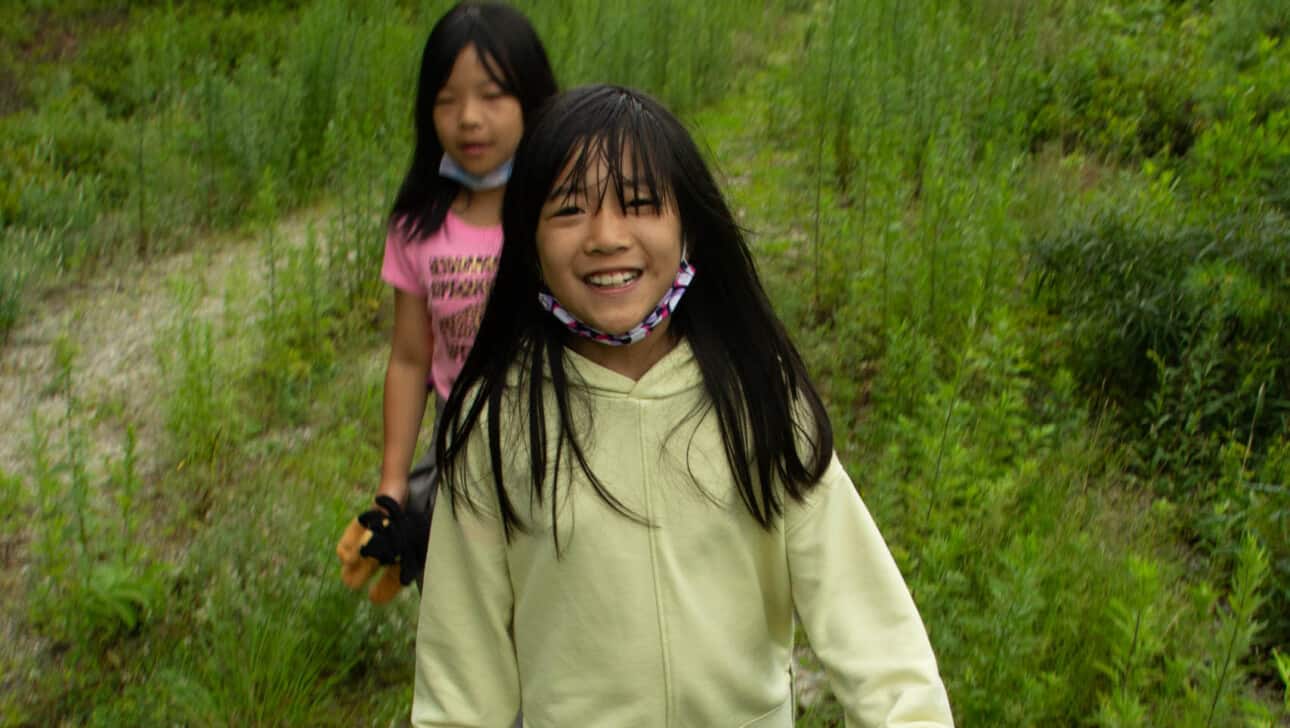 Two young girls walking down a trail.