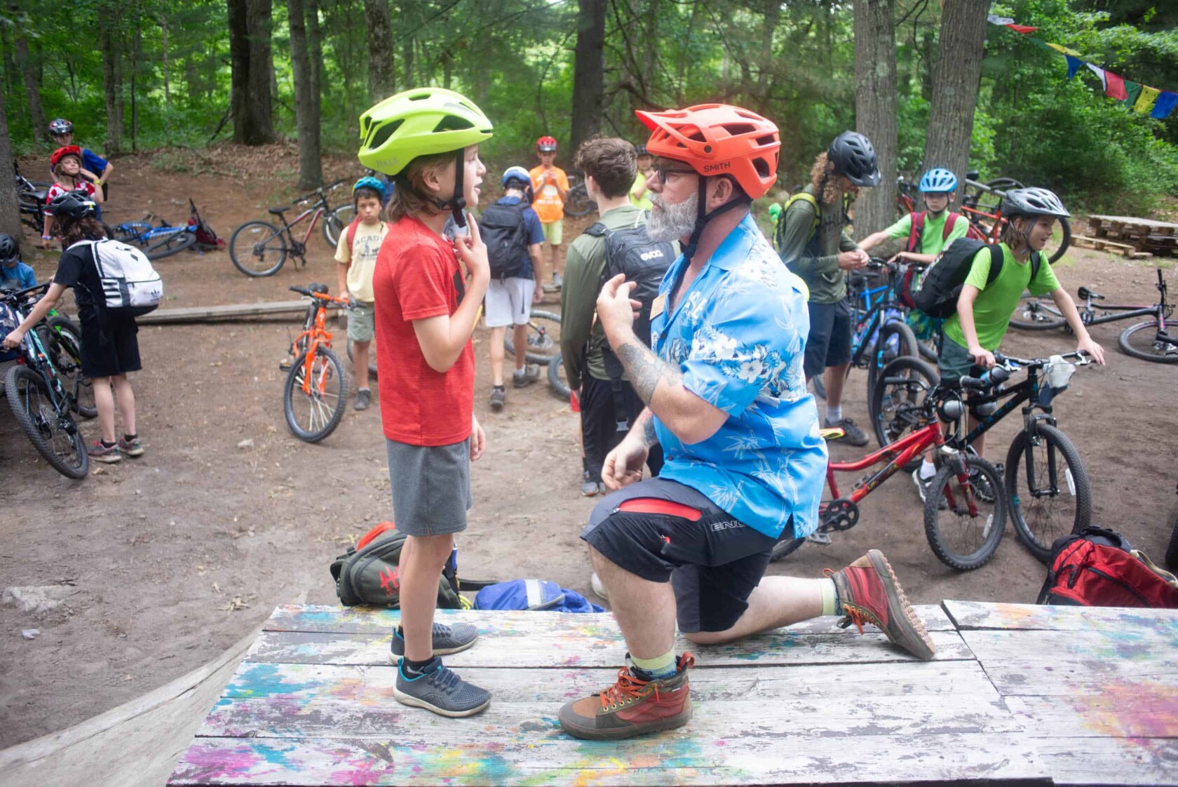A man is talking to a boy while wearing a helmet.