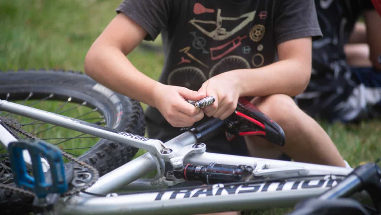 A young boy working on his bike.