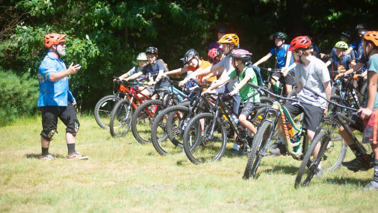 A group of people riding mountain bikes in a field.