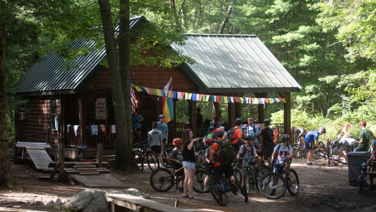 A group of people riding bikes in a wooded area.