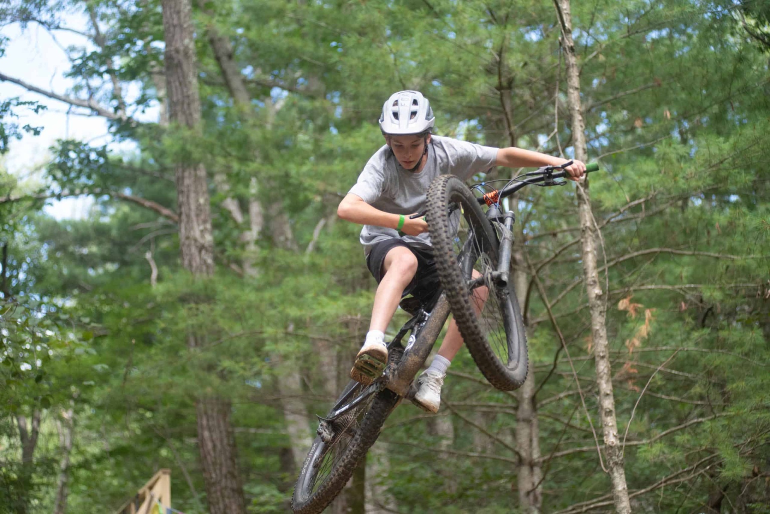 A young man riding a mountain bike in the woods.