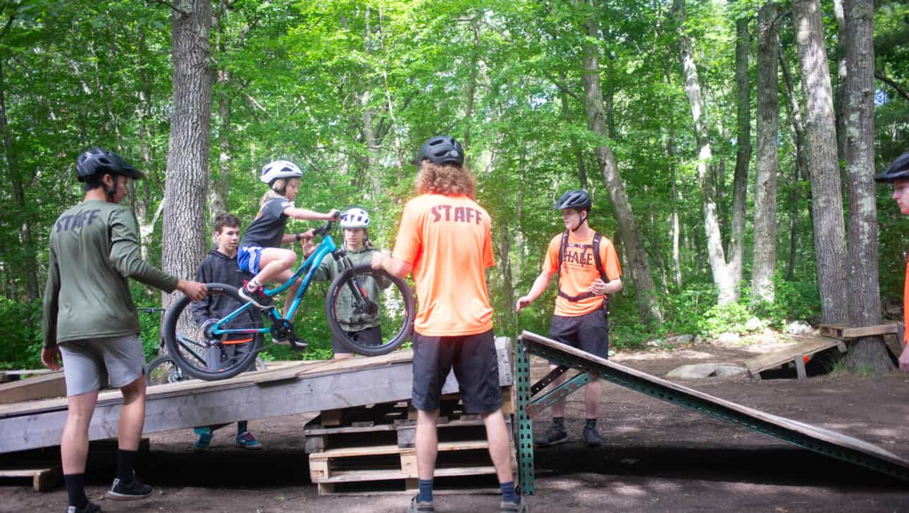 A group of people riding bikes in a wooded area.