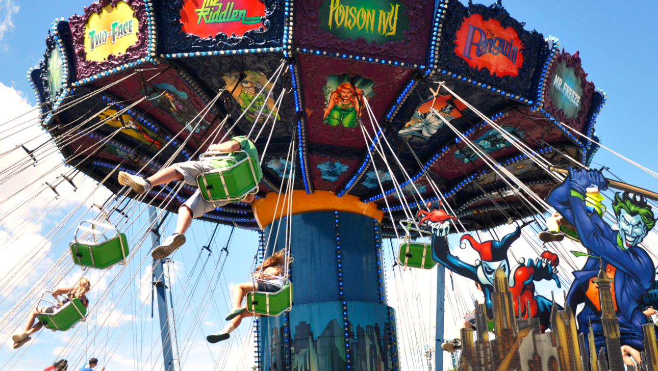 Children on theme park ride swings.