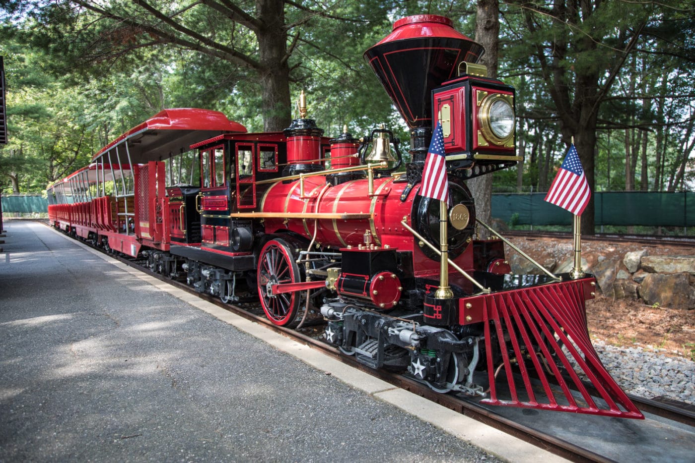 A scale replica of a steam locomotive for children to ride at an outdoor museum.