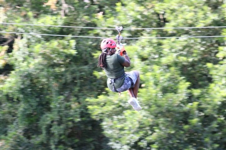 A woman zip-lining through a forest