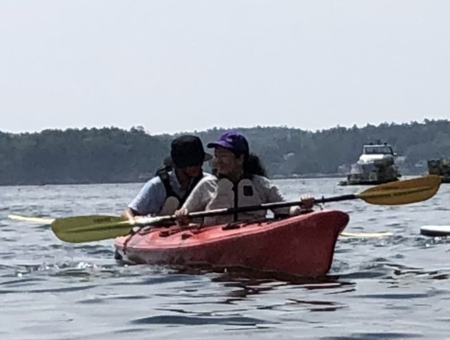 Two people paddling in a tandem kayak.