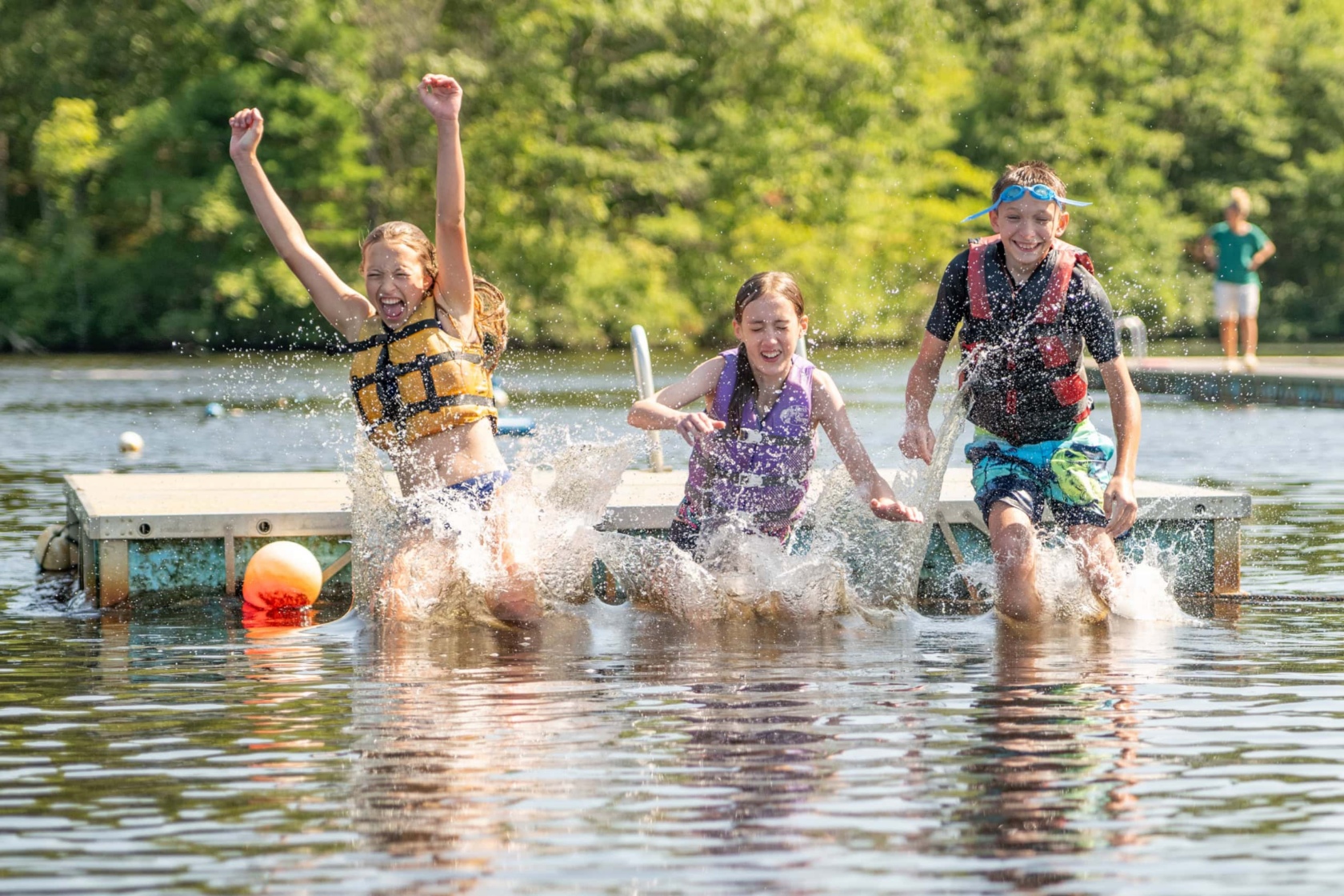 Kids enjoying water activities at the lake during outdoor summer camp.