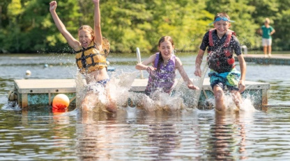 Kids enjoying water activities at the lake during outdoor summer camp.