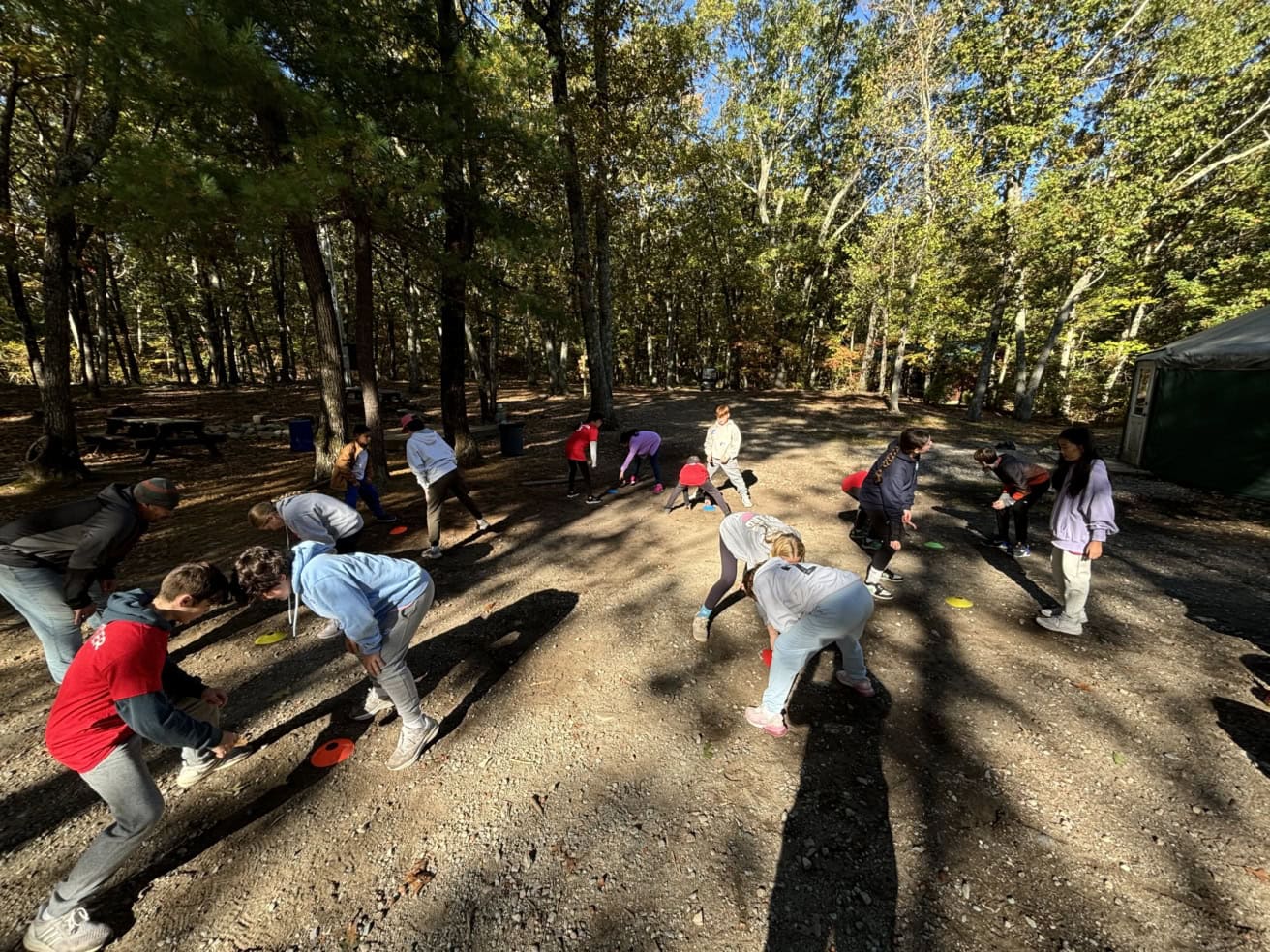 Group of people participating in an outdoor activity surrounded by trees.